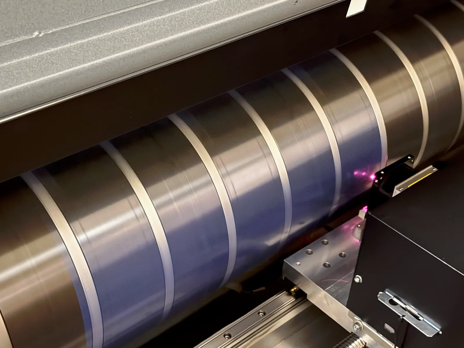 Cilindro del CTP con la placa de aluminio montada mientras el cabezal láser la graba